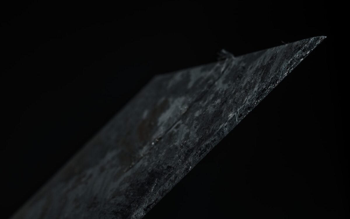 a close up of a piece of metal with a black background