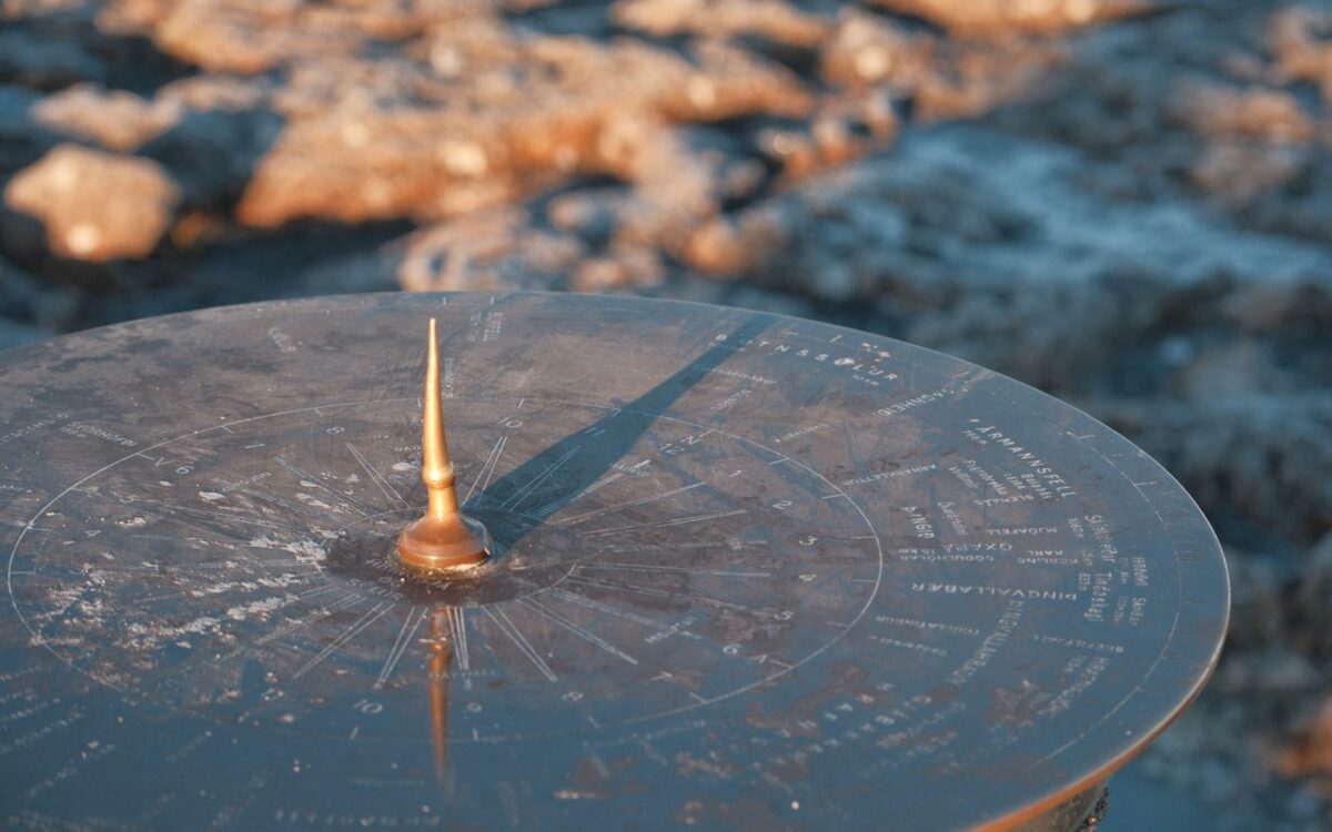 A sundial casting a shadow on a textured surface.