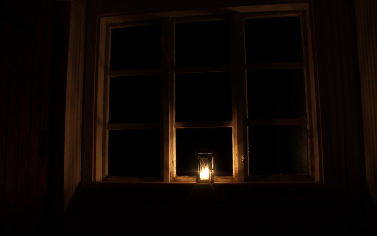 a candle is lit in front of a window