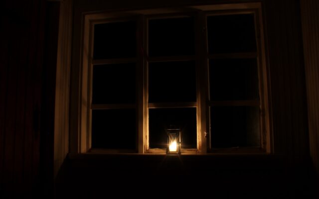 a candle is lit in front of a window