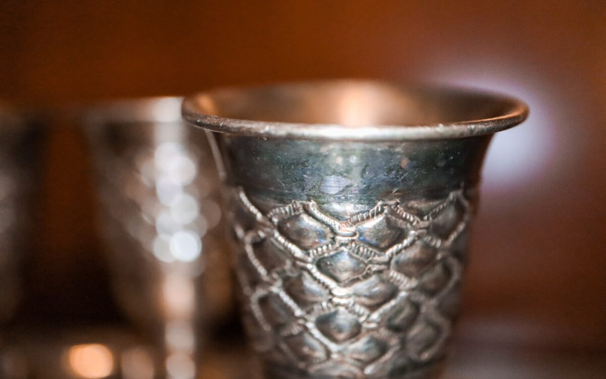 silver round bowl on brown wooden table