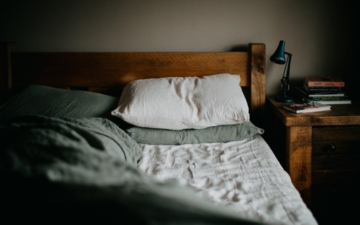 a bed with a wooden headboard and a night stand