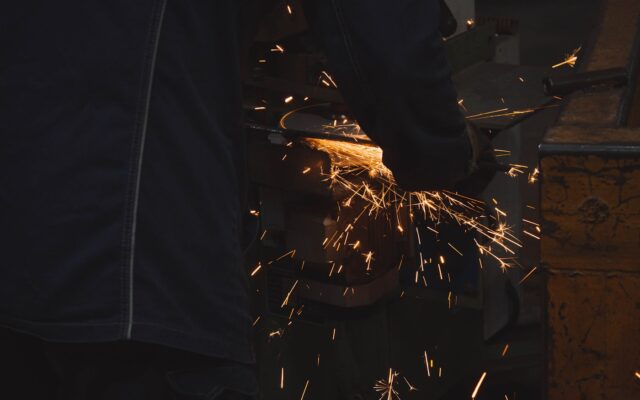 A man working with a grinder on a piece of metal
