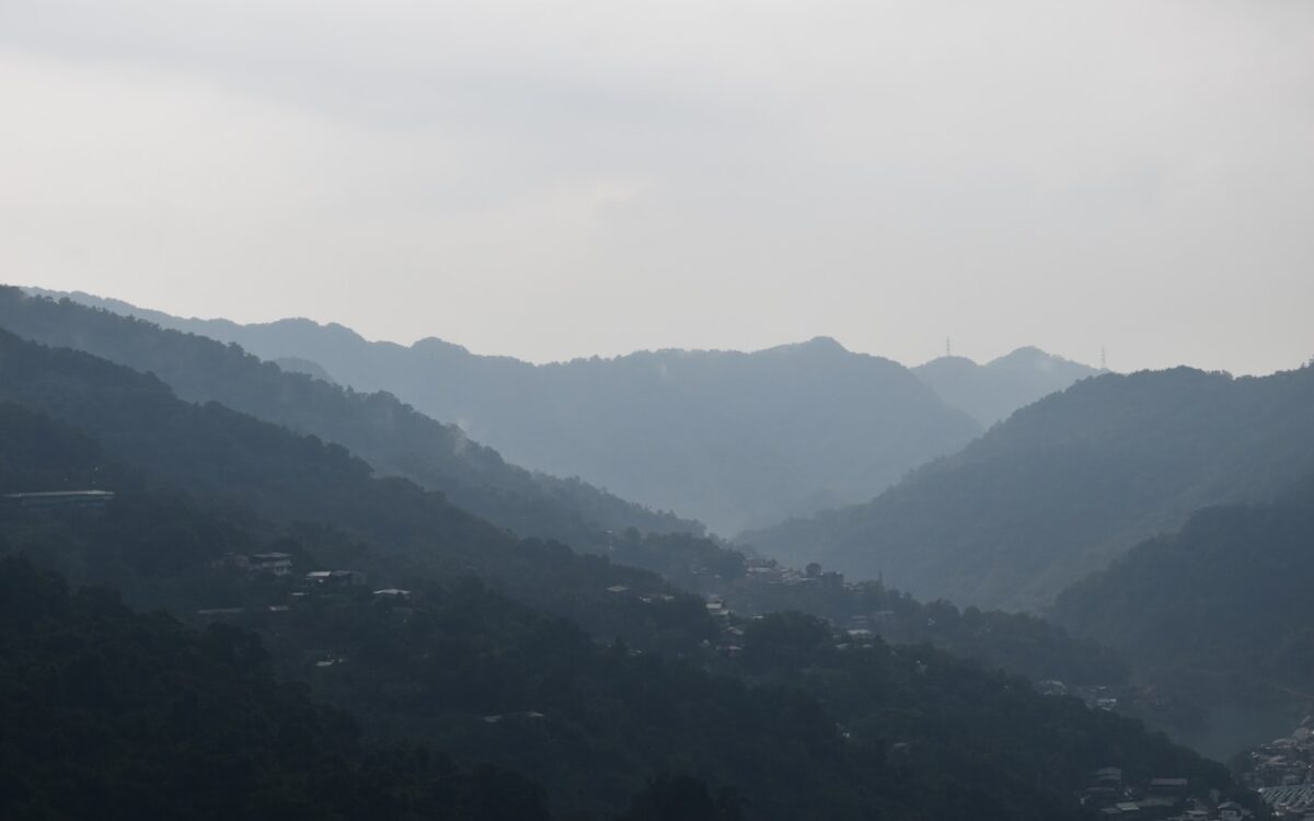 Hazy mountain range with small village nestled below.