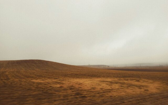Brown rolling hills under a foggy sky