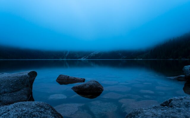 brown rock formation on body of water during daytime