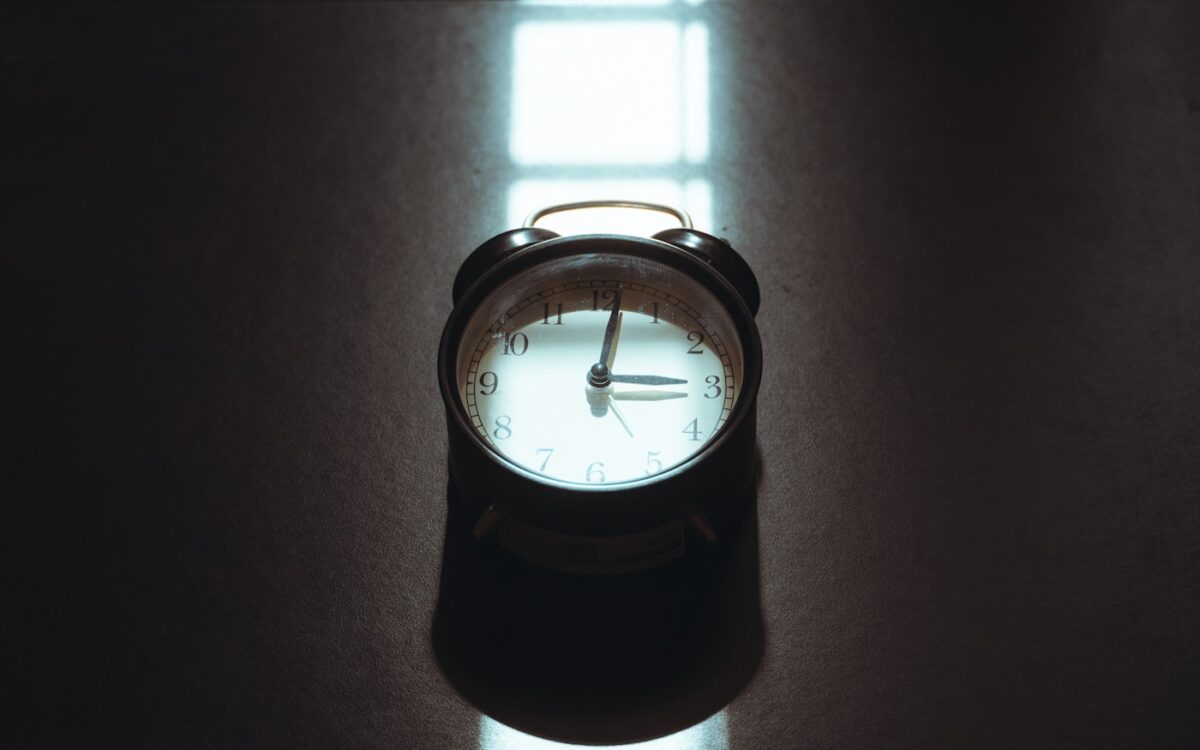 Retro alarm clock on a dark reflective surface.