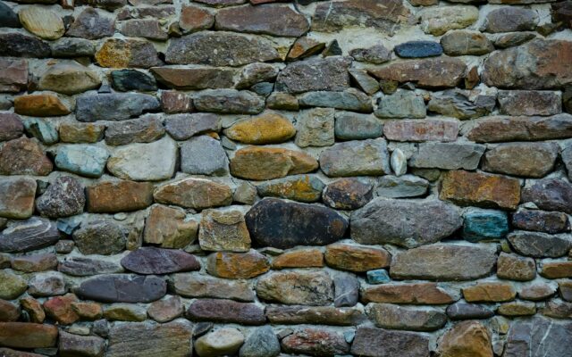 a stone wall made of various colored rocks