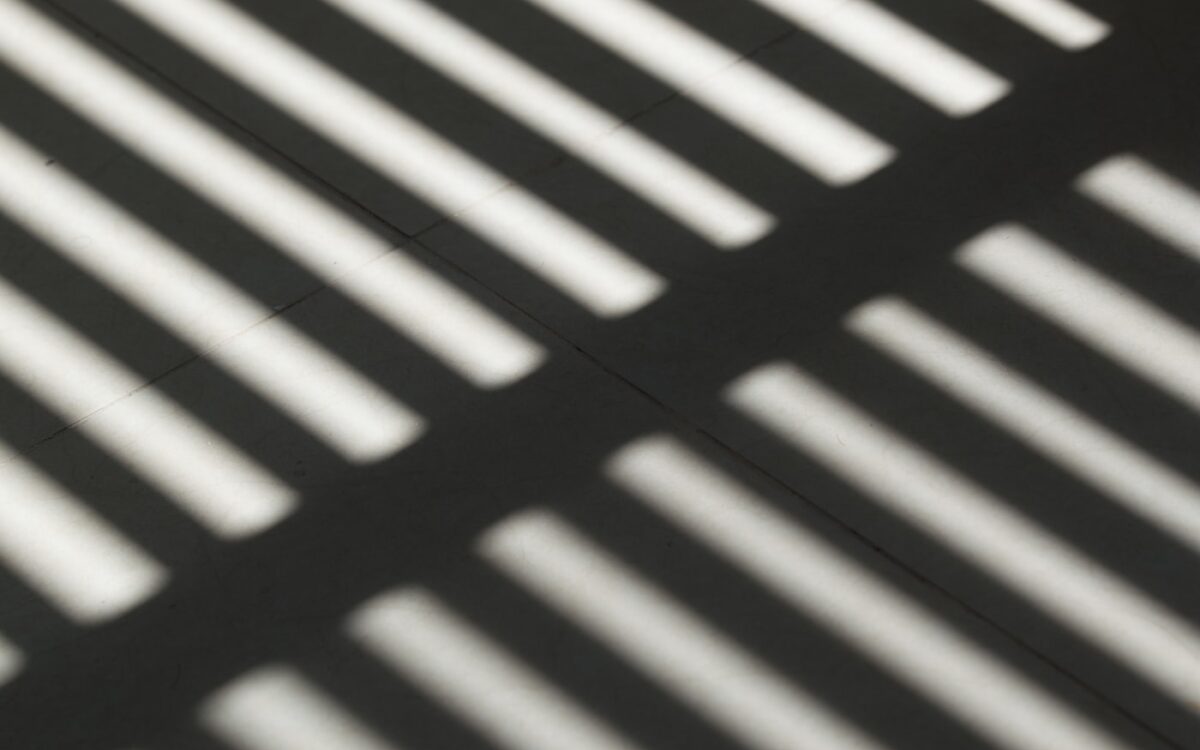the shadow of a bench on the ground