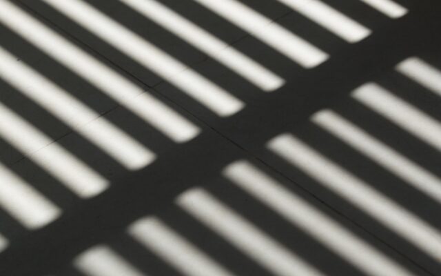 the shadow of a bench on the ground