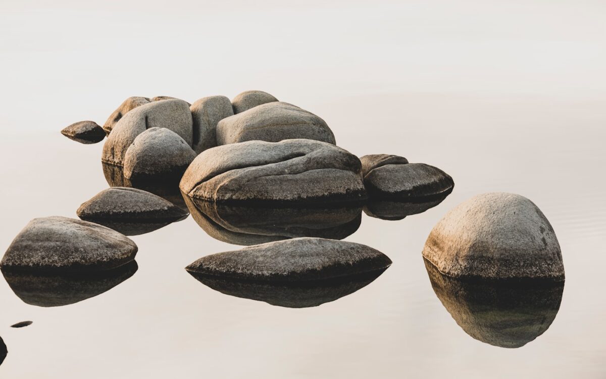 a group of rocks sitting on top of a body of water