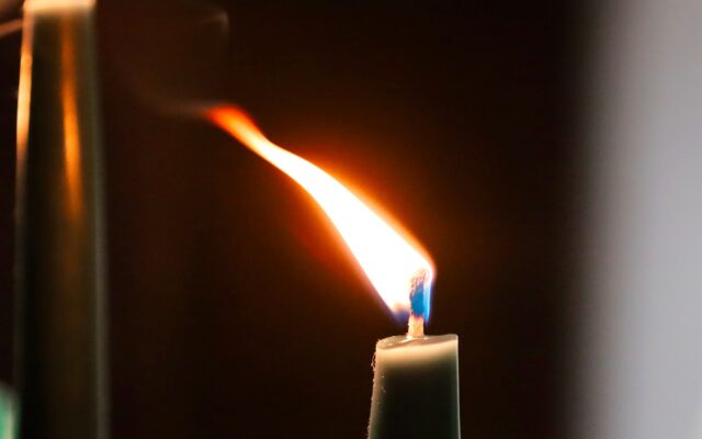 a close up of a lit candle with a blurry background
