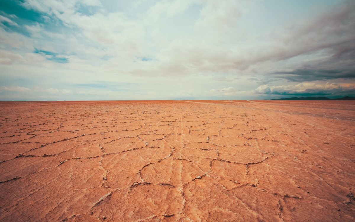 empty desert under white cloudy sky at daytime