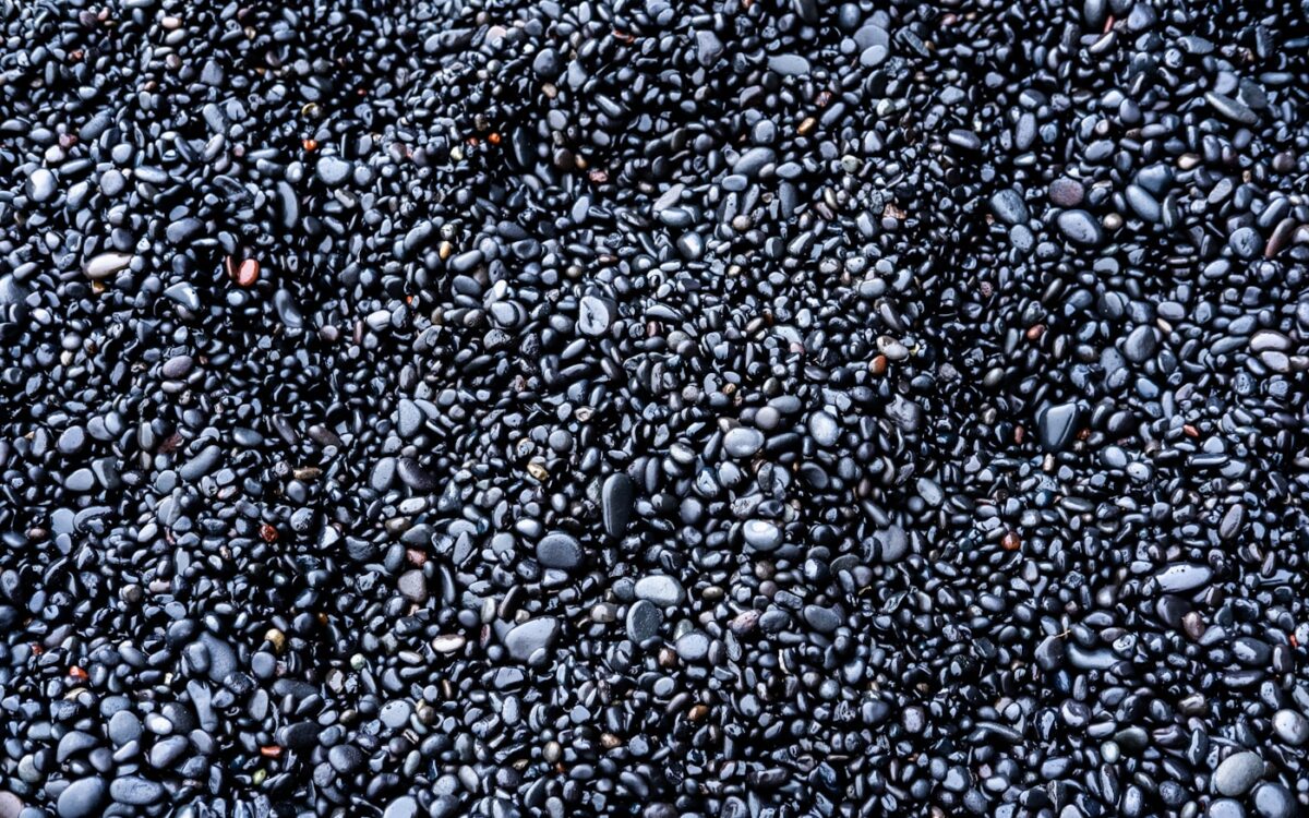 a bunch of black rocks that are on the ground