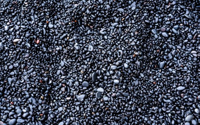 a bunch of black rocks that are on the ground