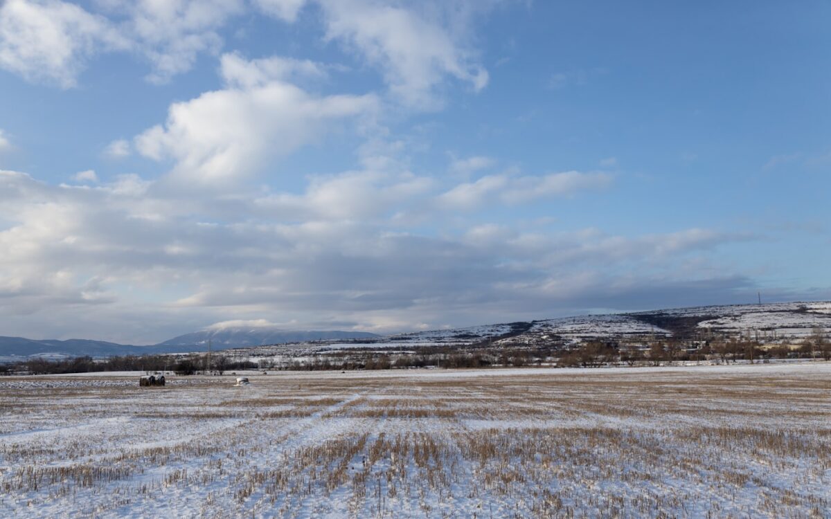 a large open field with snow on the ground