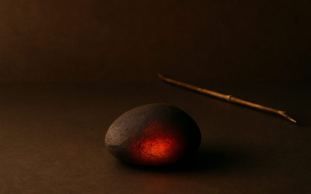 Smooth stone glowing red beside a thin twig, illustrating the 1976 Fire Dragon (Bing Chen) Chinese zodiac year