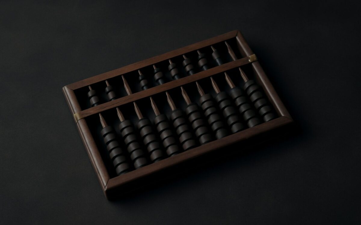 Dark wood Chinese abacus, its beads set in counted rows