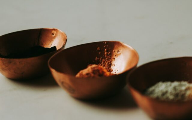 Three ceramic bowls holding muted natural pigments