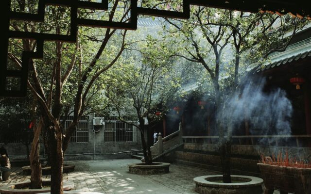 Smoke rises from incense burners in a courtyard