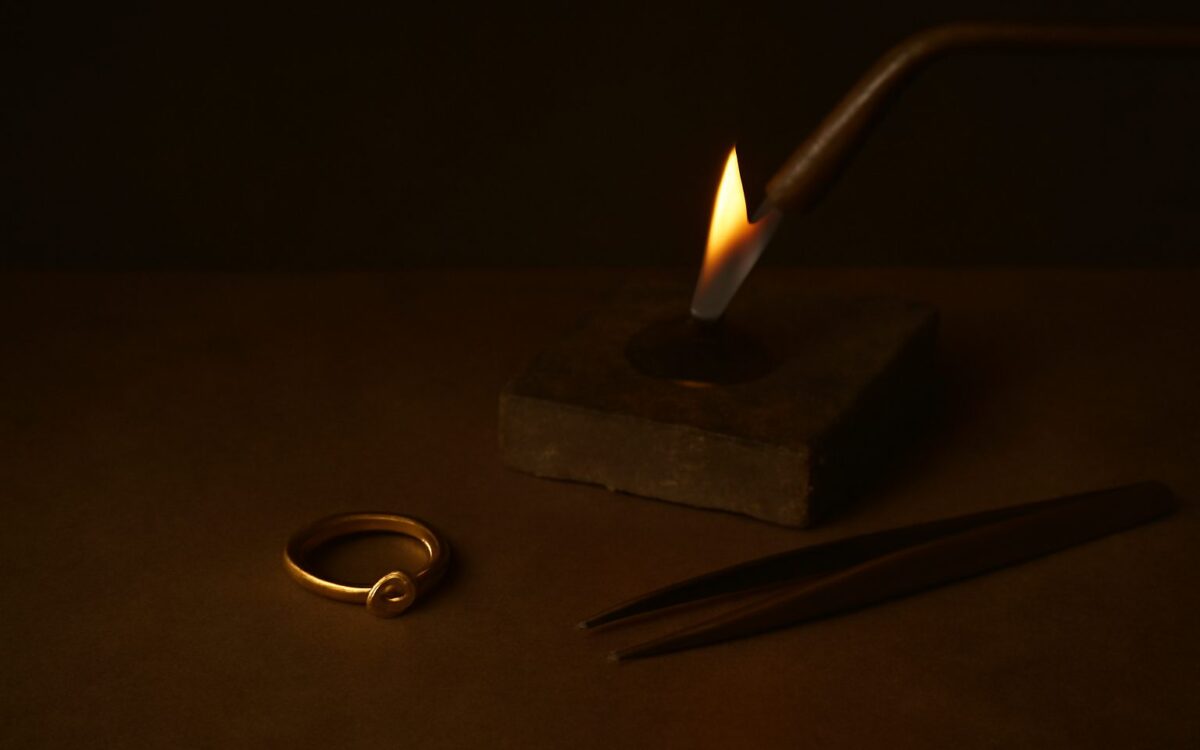 Goldsmith's flame in a dark workshop, illustrating the Xin Si day pillar in Ba Zi